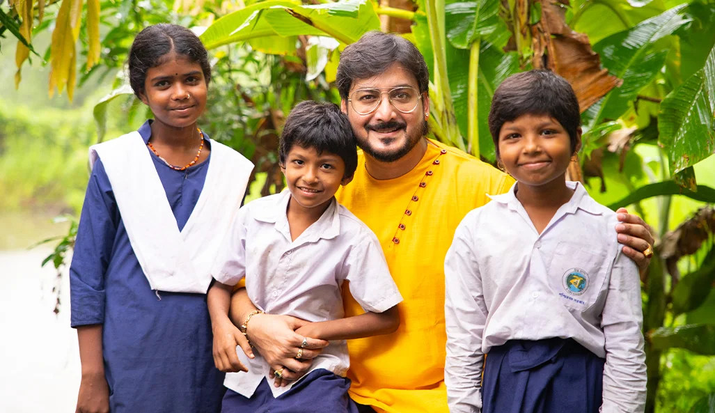 A smiling child in West Bengal holding a new school bag and books provided by Nabatara Foundation during Operation School Restart.